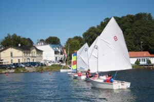 Kinder sitzen im Segelboot im Camp von Sail & Surf Rügen