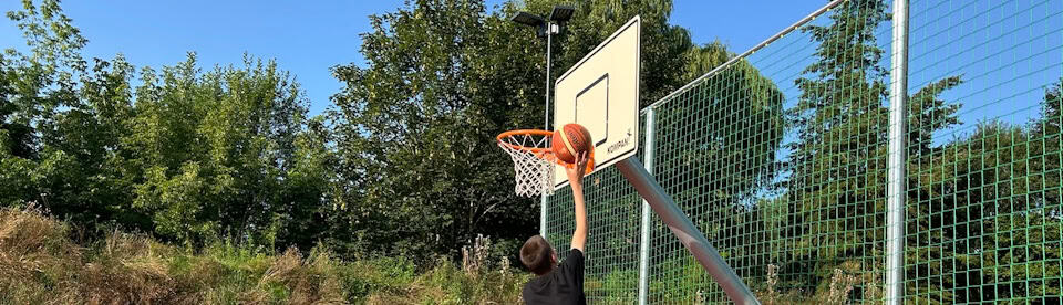 Ein Junge wirft den Basketball in den Korb