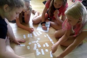 Kinder spielen ein Lernspiel mit Wortschnipseln