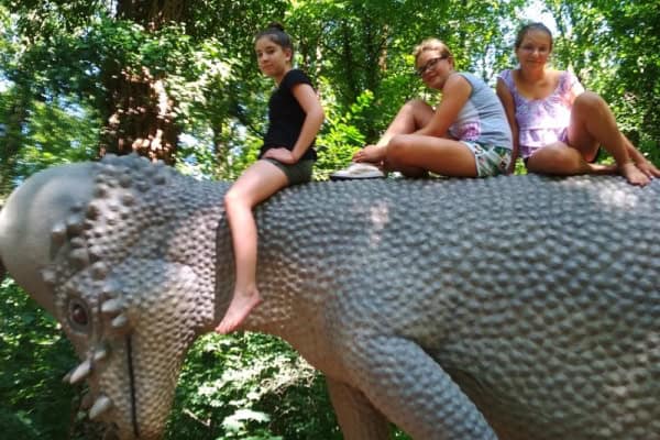 Drei Mädchen auf einem Dinosaurierrücken im Abenteuercamp Bautzen
