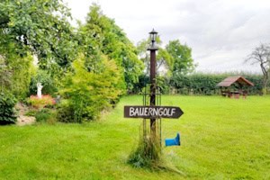 Wiese mit Wegweiser Bauerngolf im Dschungelabenteuer Camp