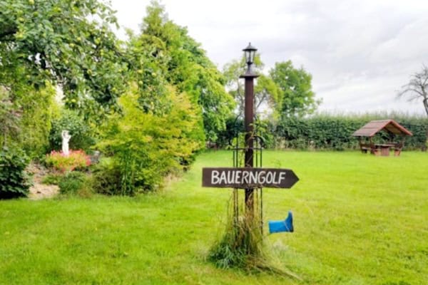 Wiese mit Wegweiser Bauerngolf im Abenteuer Dschungel Camp