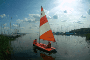 Segelboot mir zwei Kindern im Wasser