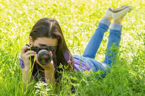 Mädchen mit Kamera im Gras
