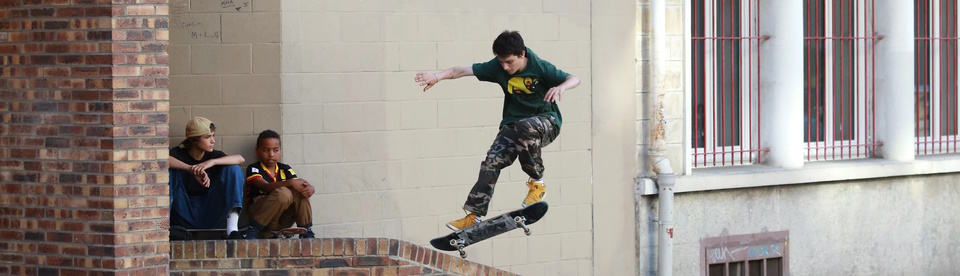 Junge springt mit einem Skateboard in die Höhe