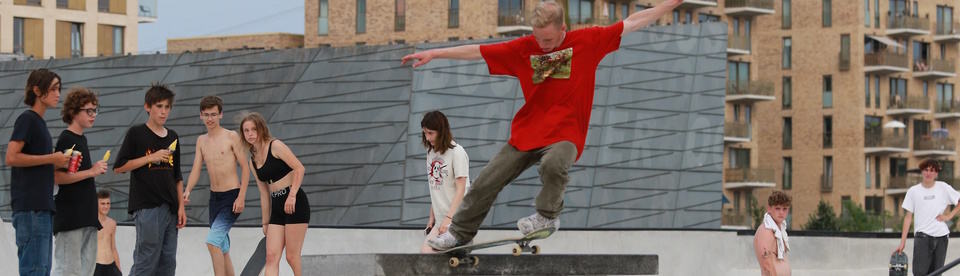 Junge springt mit einem Skateboard in die Höhe