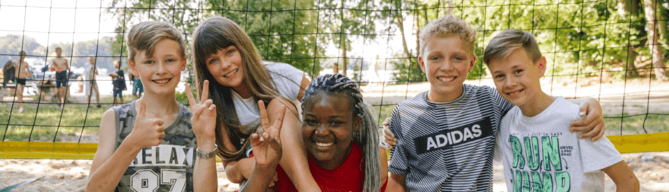 Kinder auf einem Beachvolleyballplatz