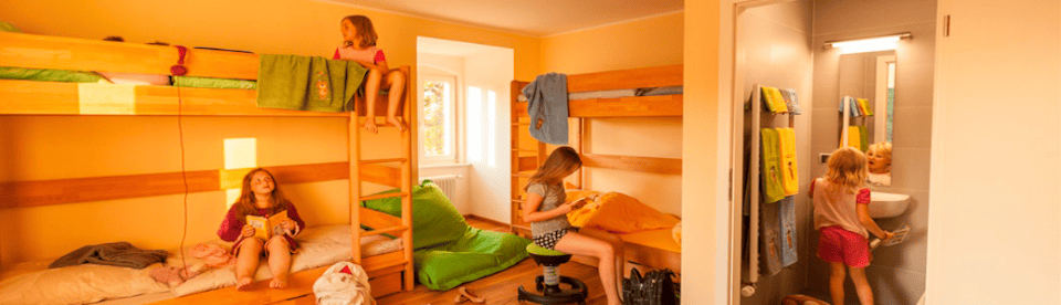 Kinder in einem Zimmer mit zwei Hochbetten