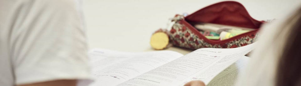 offenes Englischbuch mit Federtasche auf dem Tisch