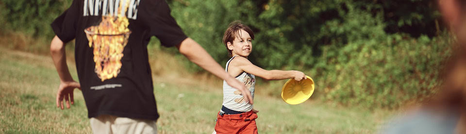 Junge wirft eine gelbe Frisbee