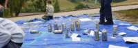 Kinder sprühen Farbe auf blauer Plane