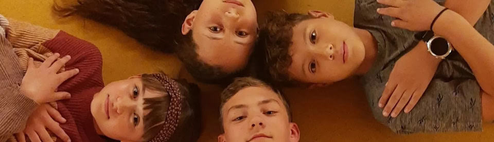Kinder werden von oben auf dem Boden liegend fotografiert
