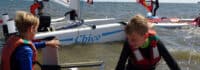 Jungsen schwimmen mit Katamaran im Wasser