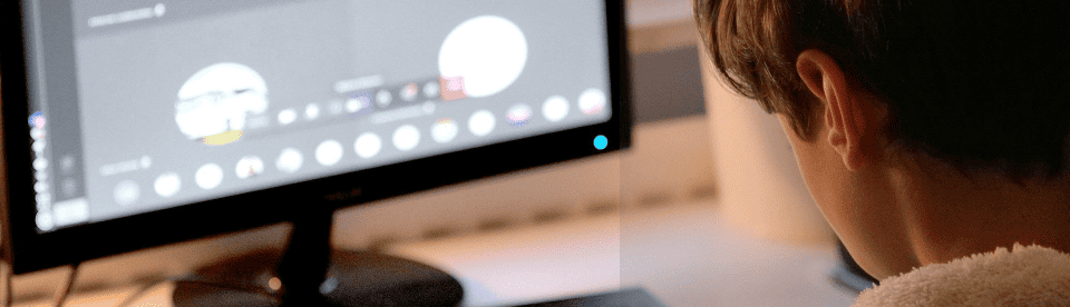 Kind sitzt vorm Laptop