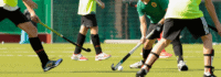 Kinder spielen Feldhockey auf einem Kunstrasenplatz