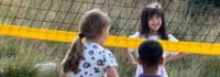 Kinder auf einem Beachvolleyballfeld