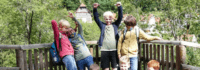 Gruppenbild glückliche Kindern vorm Holzgeländer