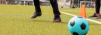 Junge nimmt Anlauf um Ball zu schießen