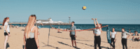 Jugendliche spielen Beachvolleyball am Strand