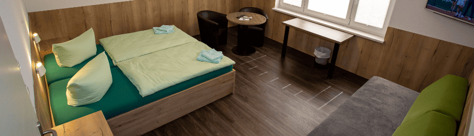 Ein modern eingerichtetes Zimmer mit Doppelbett und Couch