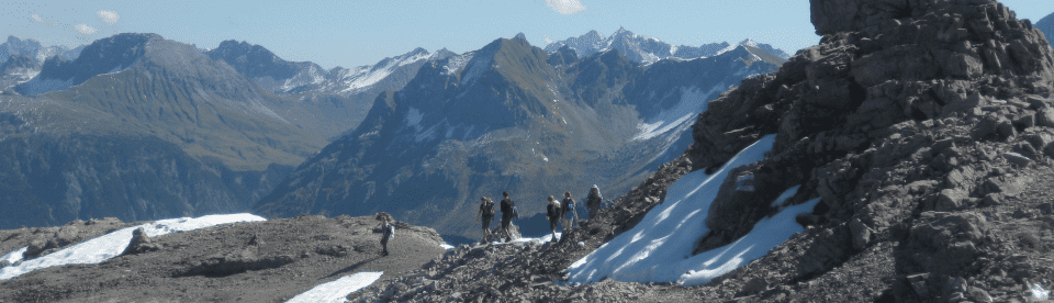 Wandergruppe in Bergen mit Schneeresten