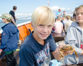 Kind mit einer Krabbe in der Hand