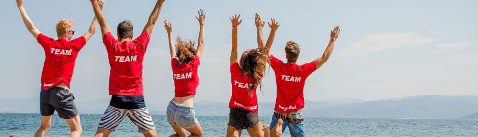 Teamer die vor dem Meer springen