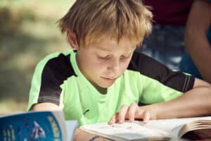 Junge liest ein englisches Buch