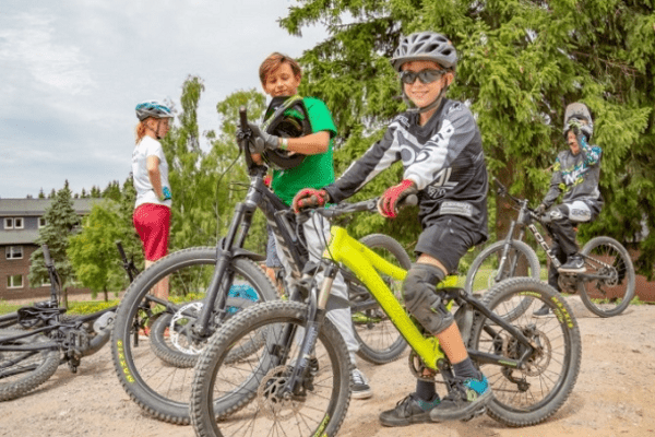 Kinder lachend auf Mountainbikes