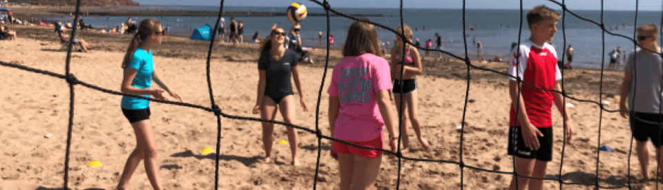 Jugendliche spielen Beachvolleyball