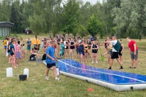 Kinder und ein Betreuer um eine Wasserrutssche