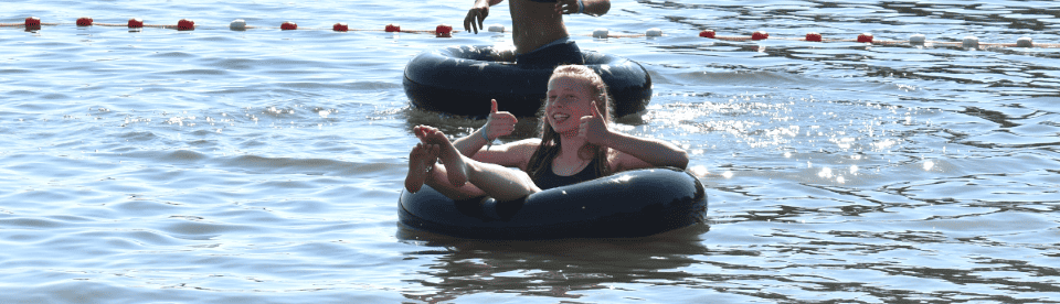 Kinder treiben in einem See auf Ringen