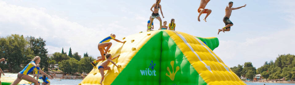 Kinder auf einer Hüpfburg im Wasser