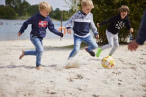 Drei Jungs beim Ball spielen am Blackfoot Beach