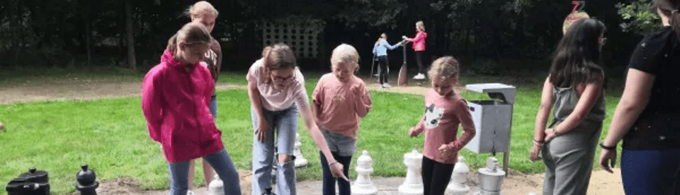 Kinder spielen Schach im Freien