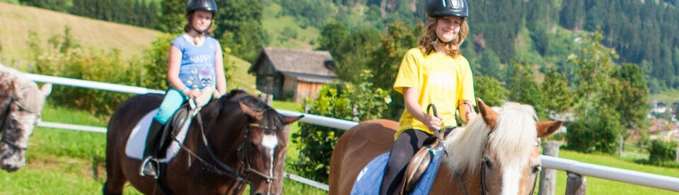 Kinder reiten in der Gruppe auf dem Platz
