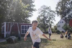 Junge lacht laufend in die Kamera