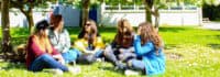 Jugendliche sitzen auf Wiese
