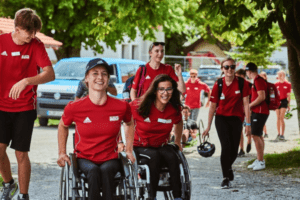 Zwei Frauen im Rollstuhl und Jugendliche drumherum