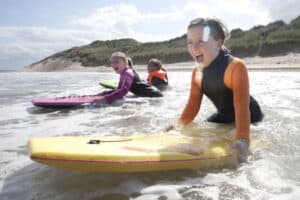 Mädchen beim Wellenreiten im Wassersportcamp auf Langeoog