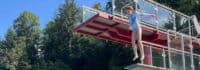 Mädchen springt vom Sprungturm im Freibad