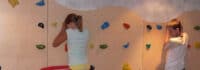 Kinder klettern an einer Kletterwand