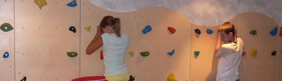 Kinder klettern an einer Kletterwand