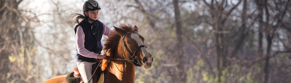 Mädchen reitet ein Pferd