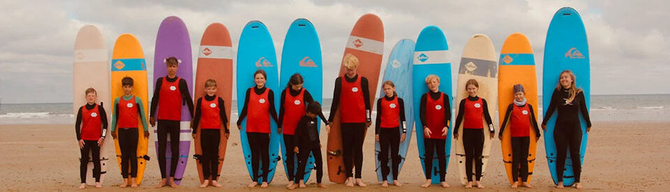 Kinder posieren mit Surfbrettern
