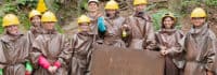 Kinder stehen mit Helm vor einer Lore