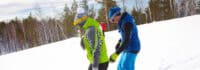 Zwei Jugendliche lernen Snowboard fahren