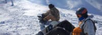Zwei Snowboarder sitzen im Schnee