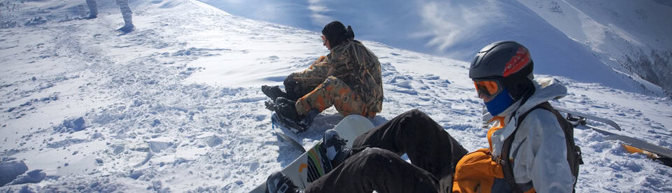 Zwei Snowboarder sitzen im Schnee