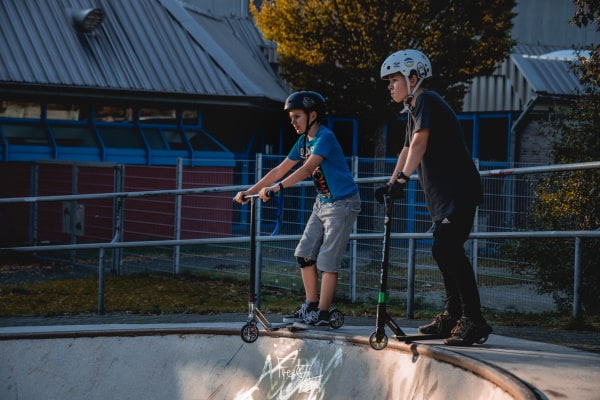 Zwei Kinder mit Scooter auf Rampe